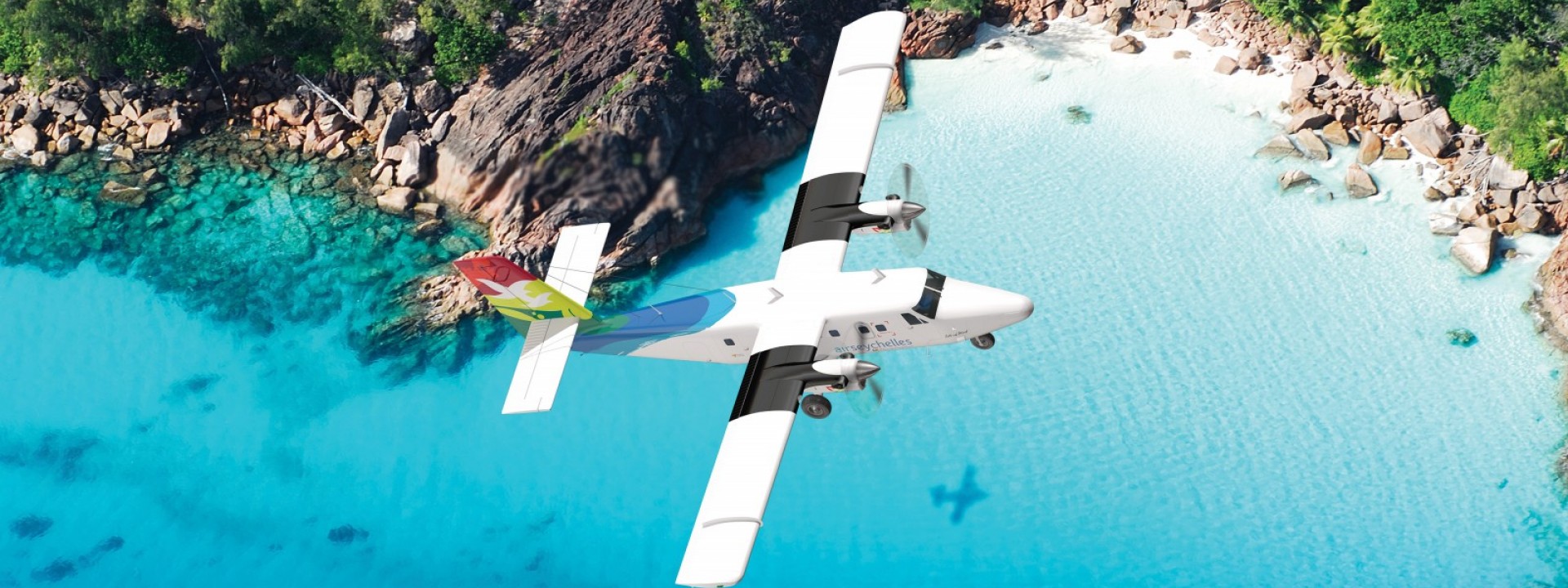 Air Seychelles Domestic Twin Otter volando sopra la spiaggia dell'isola